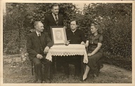 # 130  (Left to right)  Mr. Cordis, boy Heinrich Cordis, Lena Cordis (Mrs. Cordis), Marie Dehlmann; (framed photo) Wilhelm Cordis.  Siemers family?